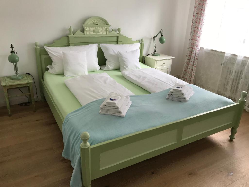 una camera da letto con un letto verde e asciugamani di Gästeträume Im Viertel a Brema