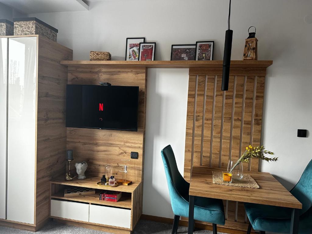 a dining room with a table and a tv at Dana Apartmani in Kopaonik