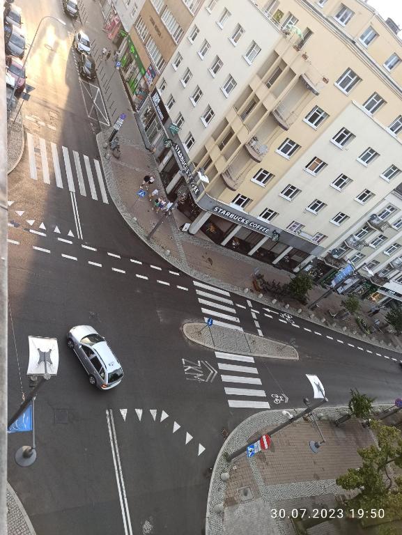 a car driving down a street in front of a building at Gdynia TOWER Apartment two rooms separate in Gdynia