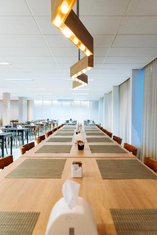 a long table in a large room with tables and chairs at Cris Hotel in Florianópolis