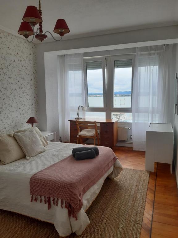 1 dormitorio con 1 cama, escritorio y ventanas en Villa Chati, en Santander