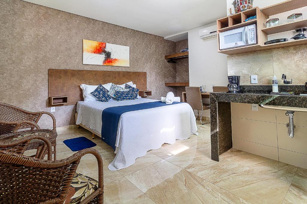 a hotel room with a bed and a kitchen at Villa Sunset in Arraial d'Ajuda