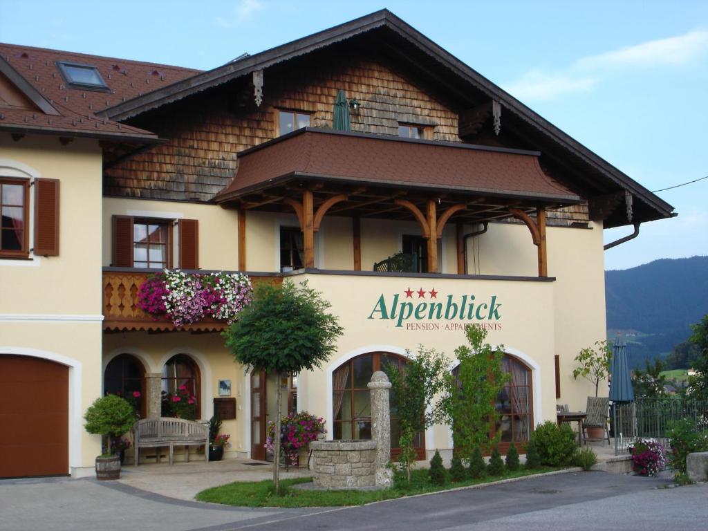 a building with a sign on the side of it at Appartements Ferienwohnungen Alpenblick in Faistenau