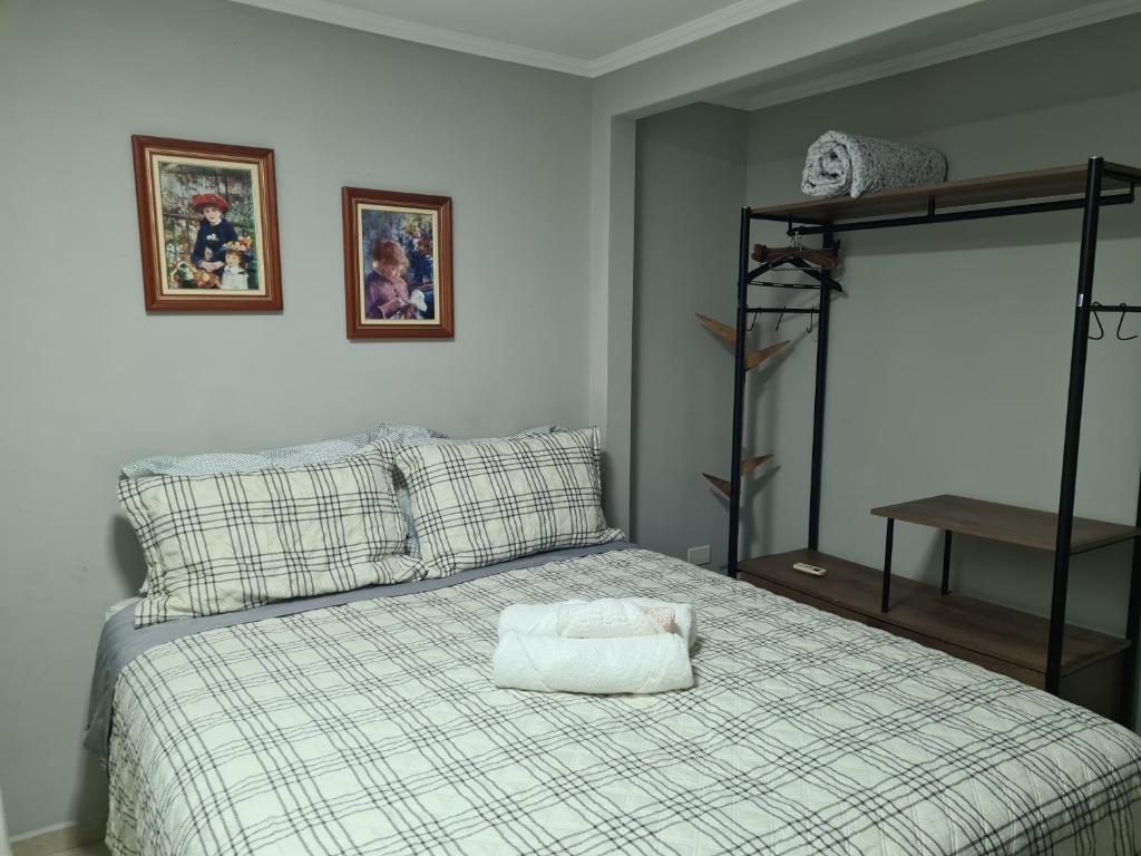 Un dormitorio con una cama con una bolsa blanca. en Quarto Jaraguá/São Luís en Jaraguá do Sul