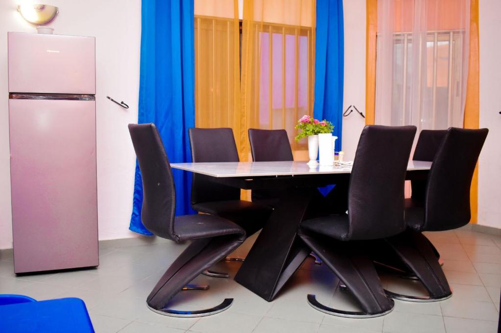 uma sala de jantar com uma mesa e cadeiras pretas em Chez mimi em Cotonou