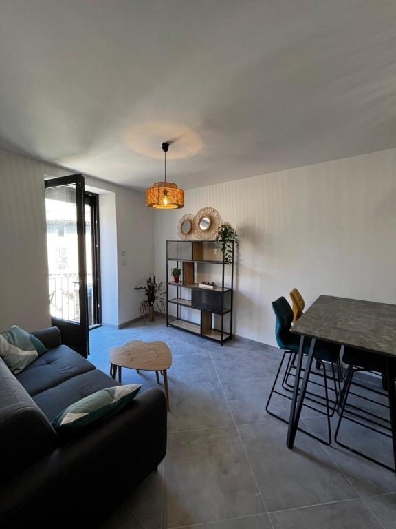 sala de estar con sofá y mesa en La Patafiole Appartement T2 calme élégant en Pont-de-Barret