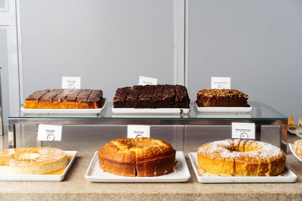 a display case filled with different types of cakes at Cris Hotel in Florianópolis
