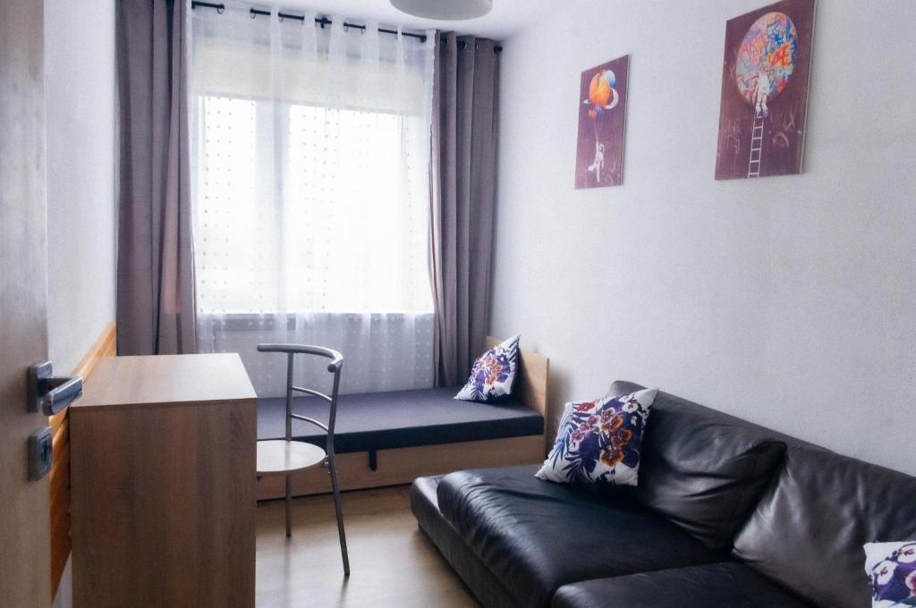 een woonkamer met een bank en een stoel bij C M Winogrady in Poznań