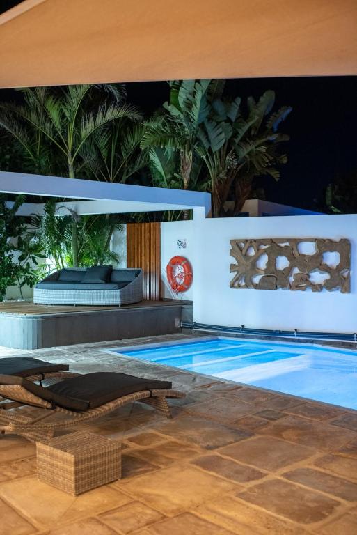 a swimming pool with a table and a chair next to it at Casa Mila with heated pool in El Roque in El Cotillo