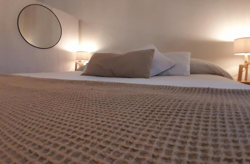 1 dormitorio con 1 cama grande y espejo en la pared en Cálido depto 2 personas- Zona residencial en Morón