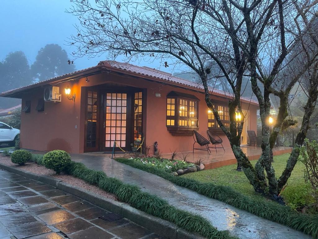une petite maison avec un arbre en face dans l'établissement Pousada Villa Cantaloa, à Gramado