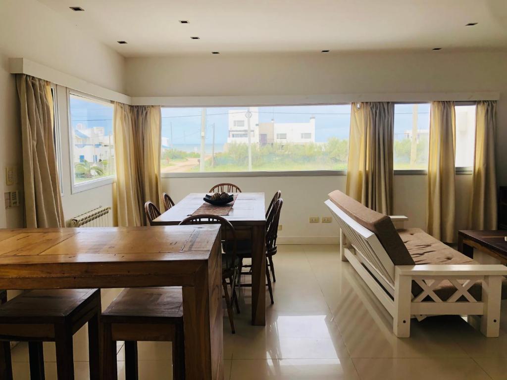 comedor con mesa y sillas y ventana grande en Casa Quequen en Quequén