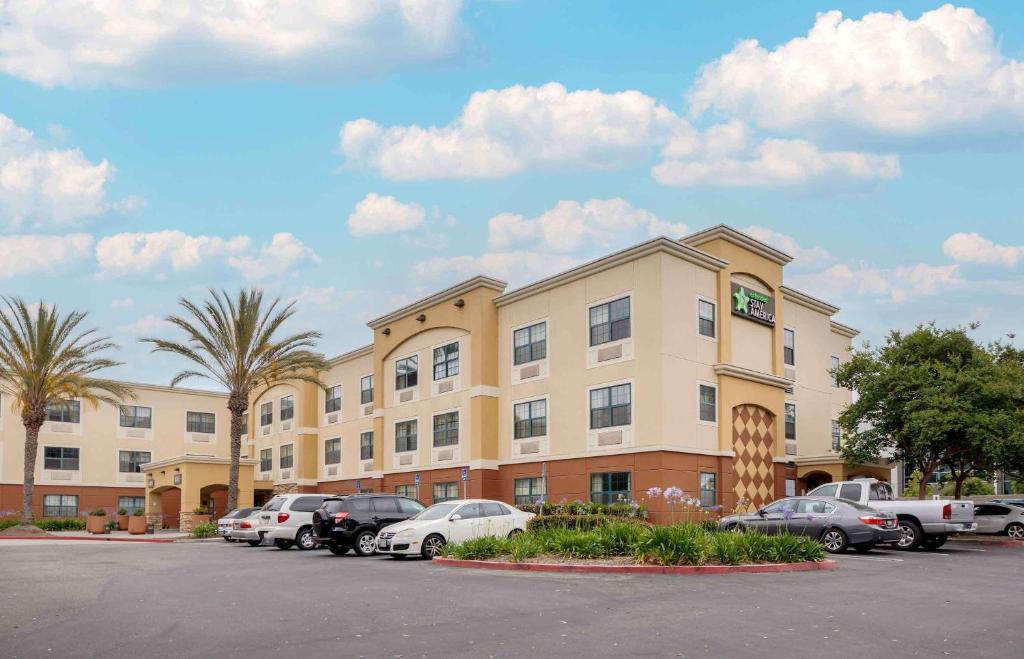 um hotel com carros estacionados num parque de estacionamento em Extended Stay America Suites - Orange County - Huntington Beach em Huntington Beach