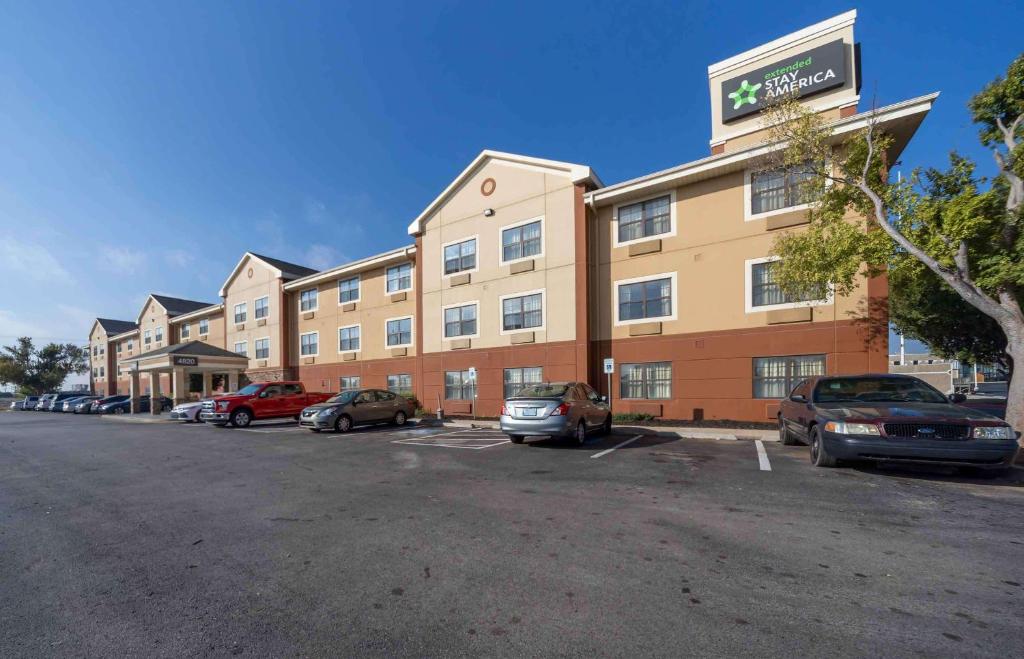 un grand bâtiment avec des voitures garées dans un parking dans l'établissement Extended Stay America Suites - Oklahoma City - Airport, à Oklahoma City