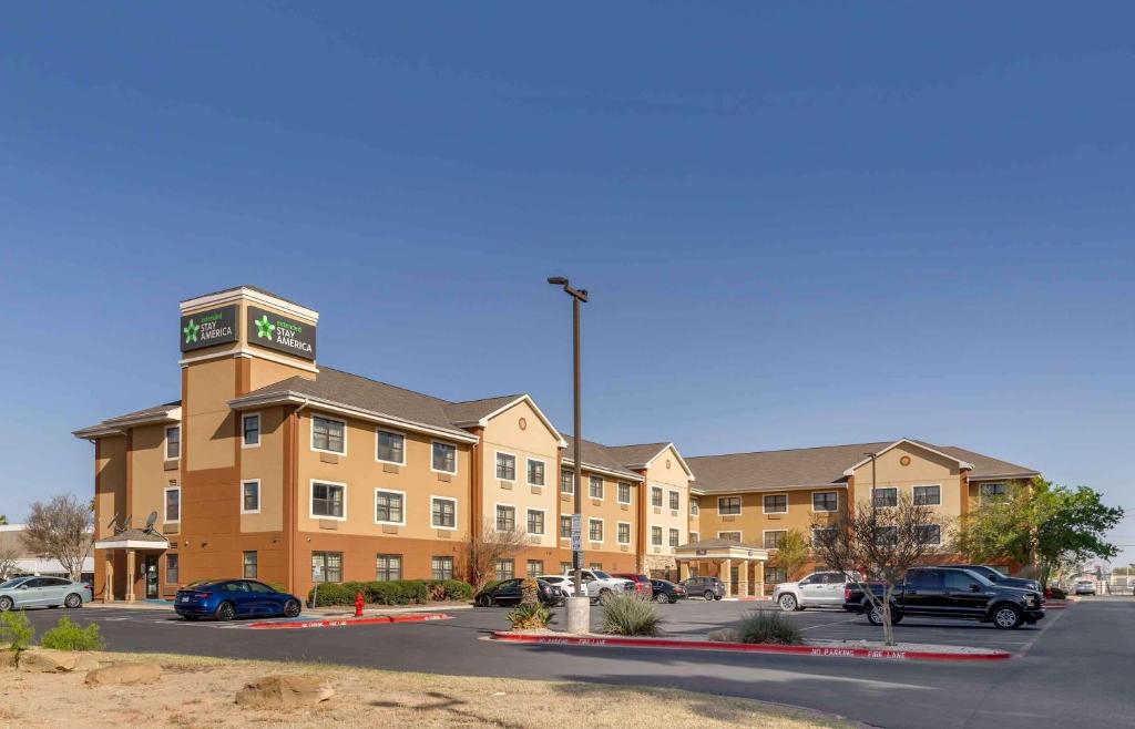 un grand bâtiment avec des voitures garées dans un parking dans l'établissement Extended Stay America Suites - Laredo - Del Mar, à Laredo