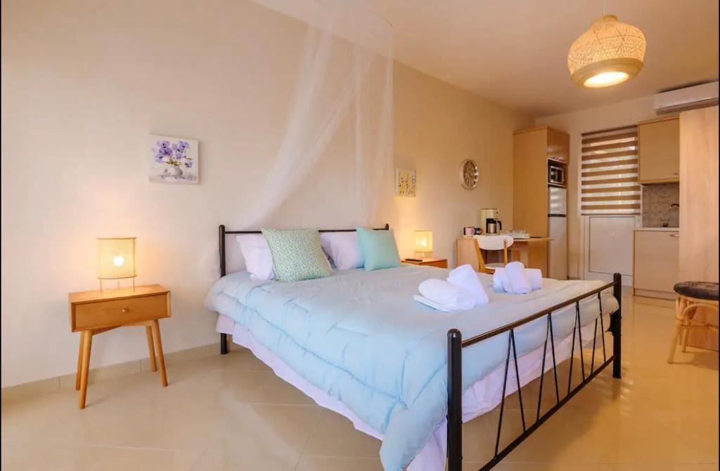 a bedroom with a large bed and a kitchen at Marathon Luxury Suites - Studio in Schinias