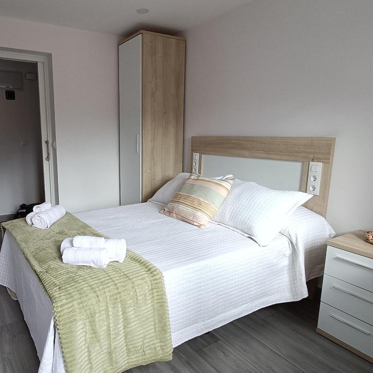 a bedroom with a large bed with towels on it at Las Gaviotas Cudillero in Cudillero