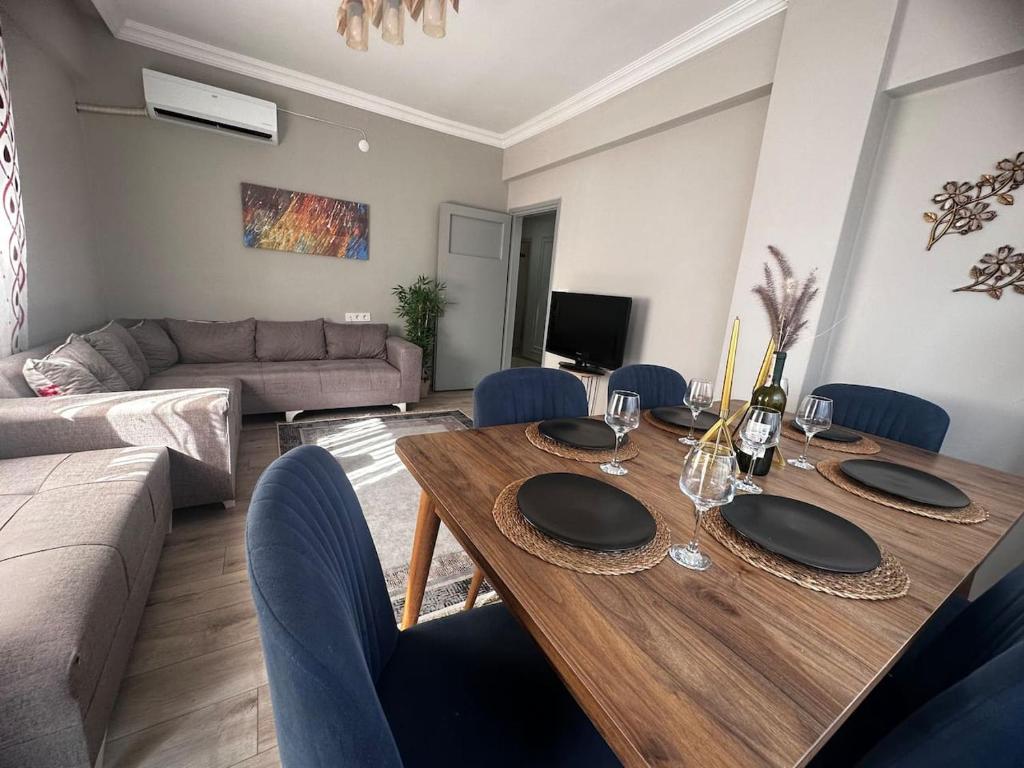 sala de estar con mesa de madera y sillas azules en 300 meters to Konyaaltı beach 2+1 large and spacious apartment, en Antalya