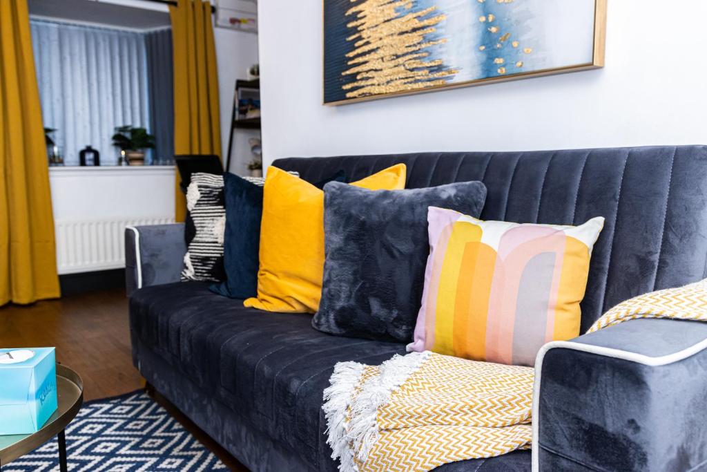 un sofá negro con almohadas coloridas en la sala de estar. en TD Carsh Wolverhampton - Luxurious 2 Bed House - Sleeps 6 - Perfect for Long Stay Workers - Leisure - Families en Wolverhampton