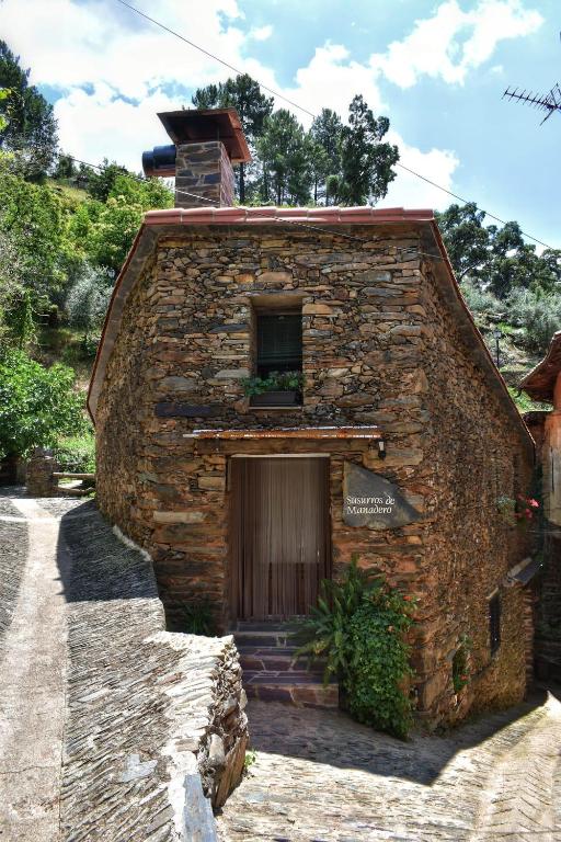 a brick building with a door and a window at Susurros del Manadero in Robledillo de Gata