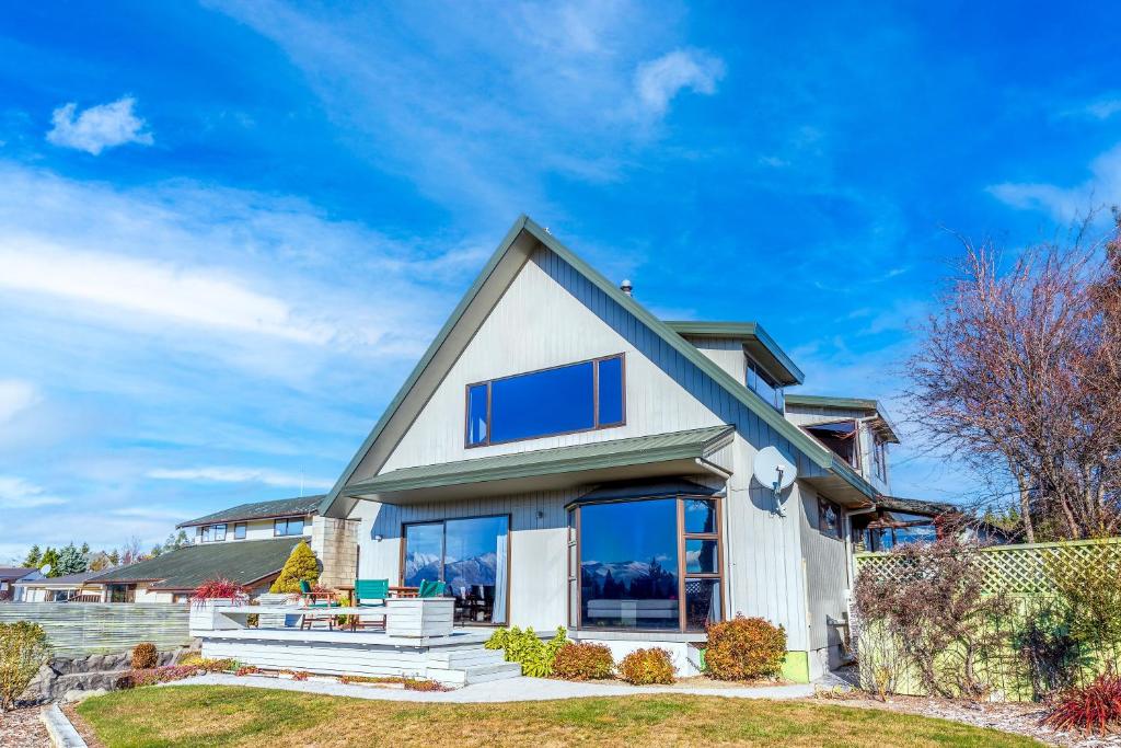 une maison blanche avec des fenêtres bleues dans l'établissement Lake House - Lake Tekapo, à Lac Tekapo