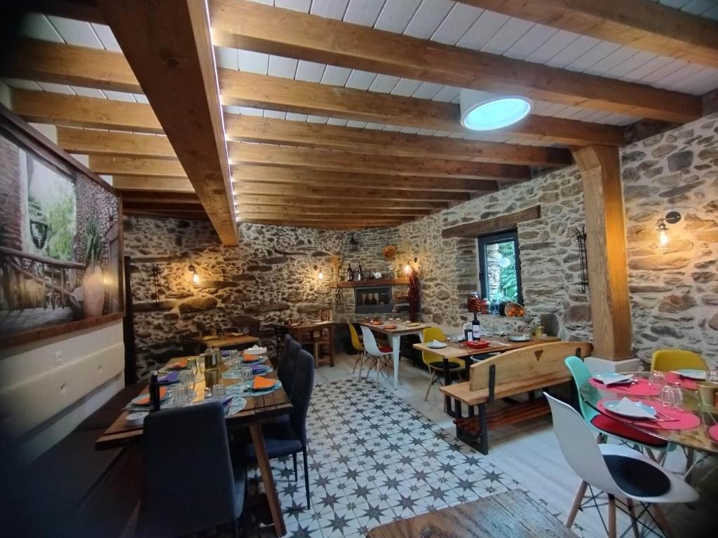 un restaurant avec des plafonds en bois, des tables et des chaises dans l'établissement Susurros del Manadero, à Robledillo de Gata