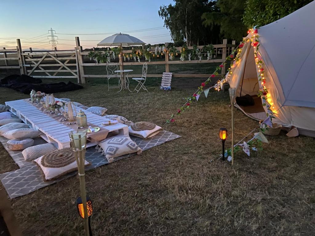 a picnic table with a tent in the grass at Country Bumpkins Luxury Glamping in Wellingore