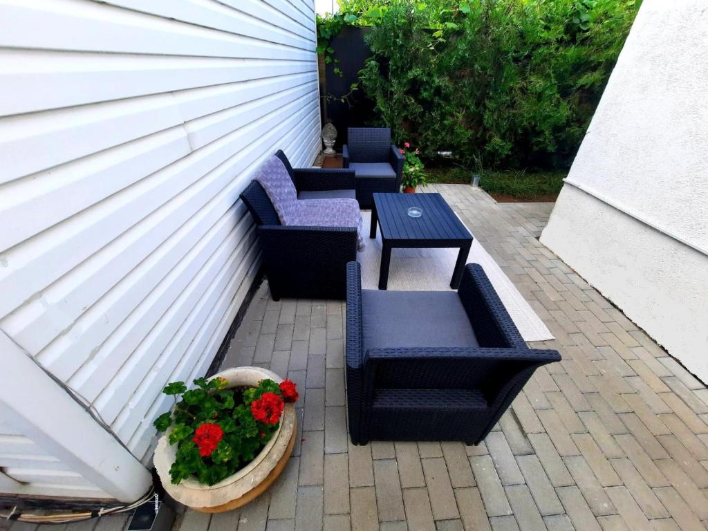 a patio with four chairs and a table and flowers at Bucharest Wheel View in Bucharest