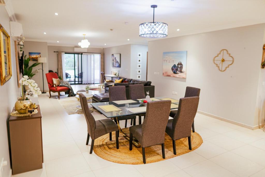 a dining room and living room with a table and chairs at The Gem in Accra