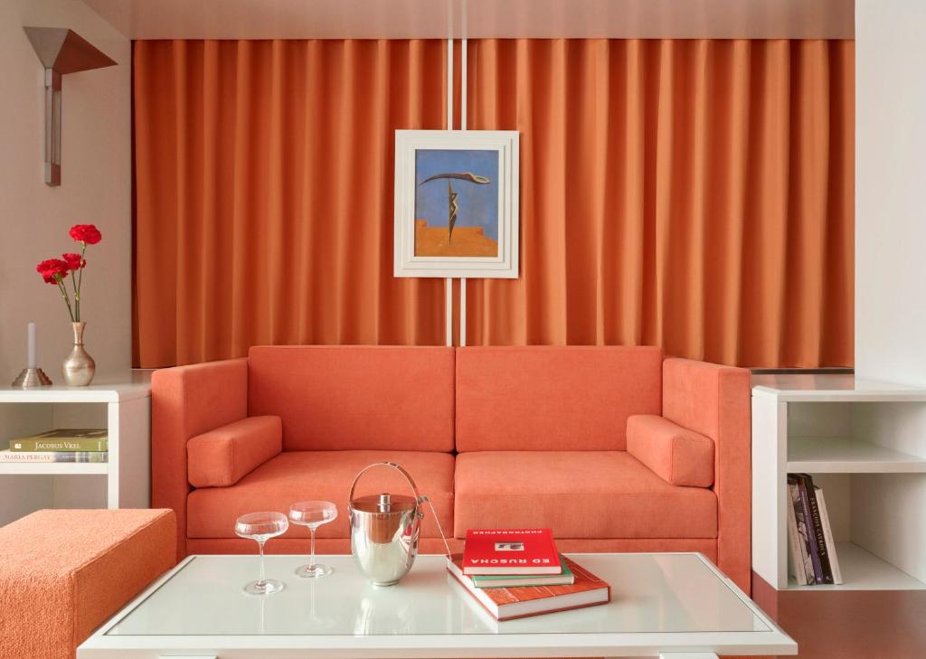 パリにあるPied A Terre - Arts et Métiersのリビングルーム(オレンジ色のソファ、テーブル付)