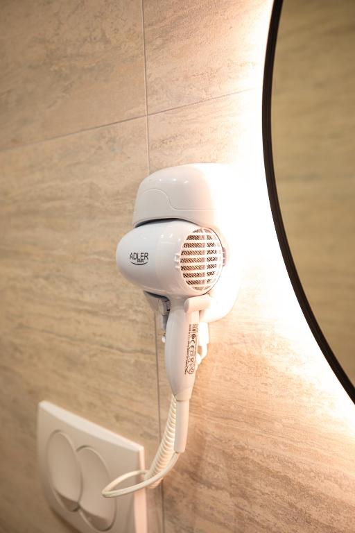 a hair dryer hanging from a wall in a mirror at Vlore Luxury Apartaments "FAEL" in Vlorë