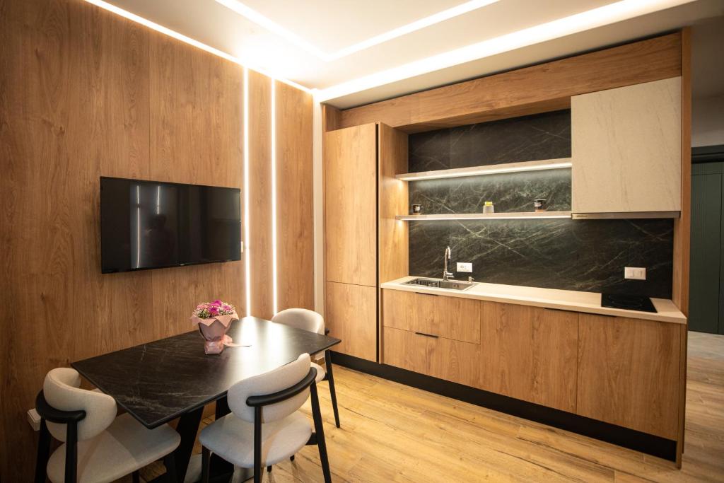 a dining room with a table and chairs and a television at Vlore Luxury Apartaments "FAEL" in Vlorë