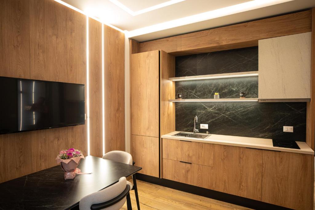 a dining room with a table and chairs and a kitchen at Vlore Luxury Apartaments "FAEL" in Vlorë