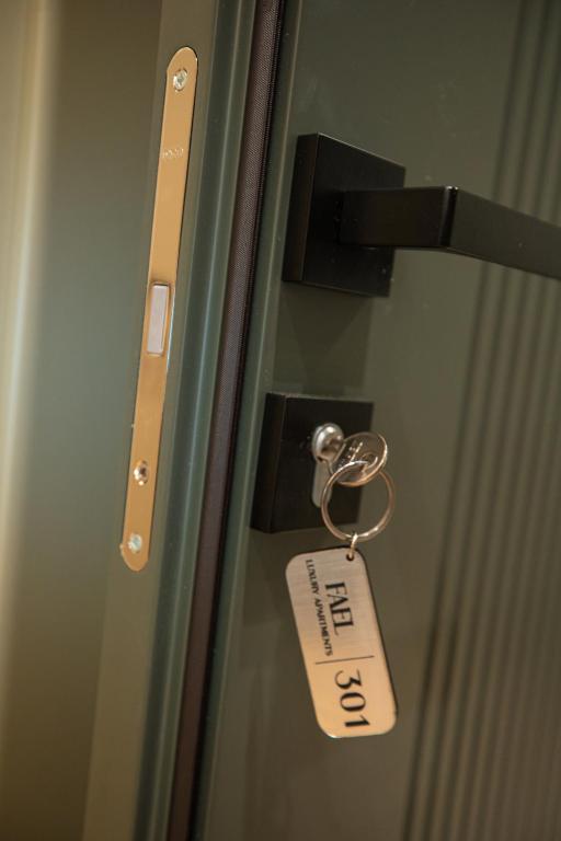 a doorhandle with a tag on a glass door at Vlore Luxury Apartaments "FAEL" in Vlorë