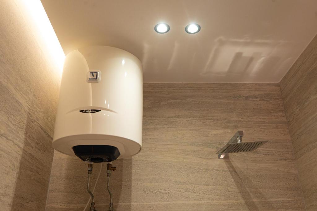 a white soap dispenser on a wall with a wooden floor at Vlore Luxury Apartaments "FAEL" in Vlorë