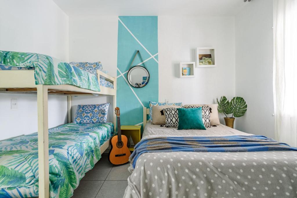 1 dormitorio con 2 literas y guitarra en Pinheira Beach House com Jacuzzi en Palhoça