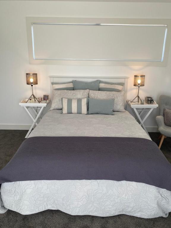 a bedroom with a large bed with two lamps at Views on Victory in Taupo