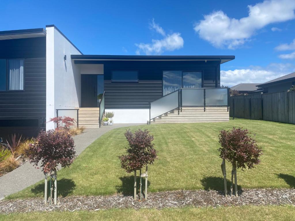 a house with two trees in the front yard at Views on Victory in Taupo