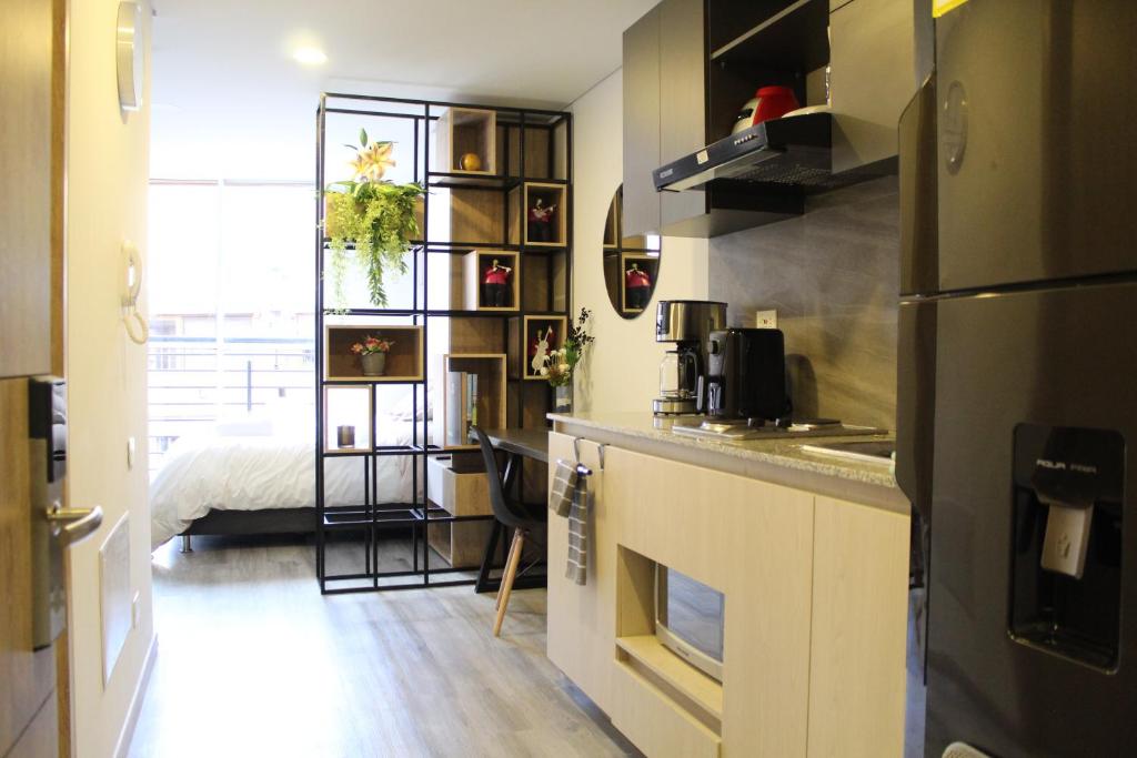 a small kitchen with a counter and a bed in a room at Loft between best business centers & restobars in Bogotá