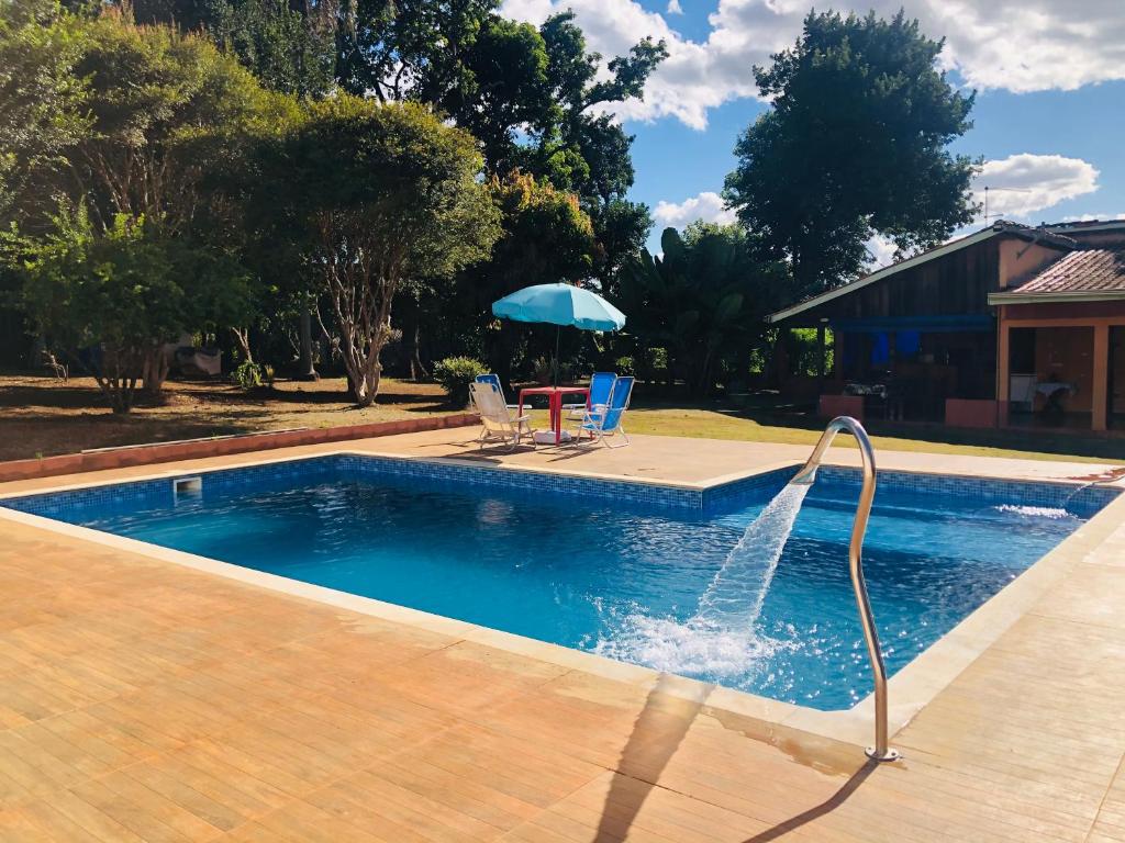 a pool with a water fountain in a yard at Recanto CharaBerbel in Salto de Pirapora