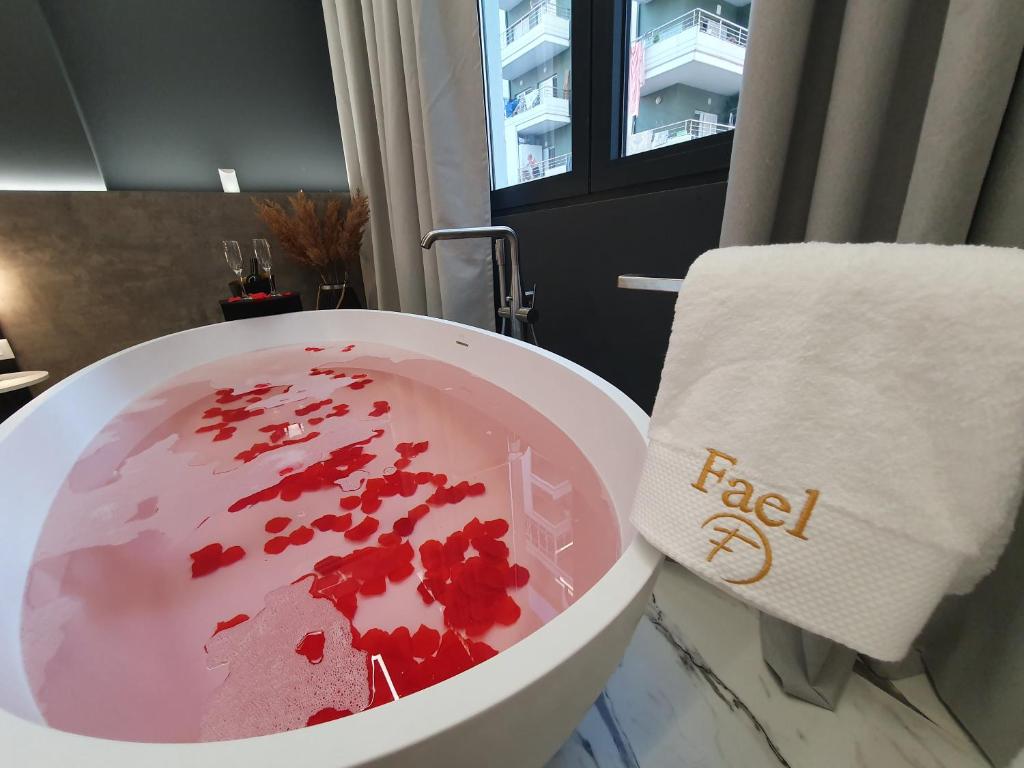a bowl of red liquid sitting on a counter in a bathroom at Vlore Luxury Apartaments "FAEL" in Vlorë
