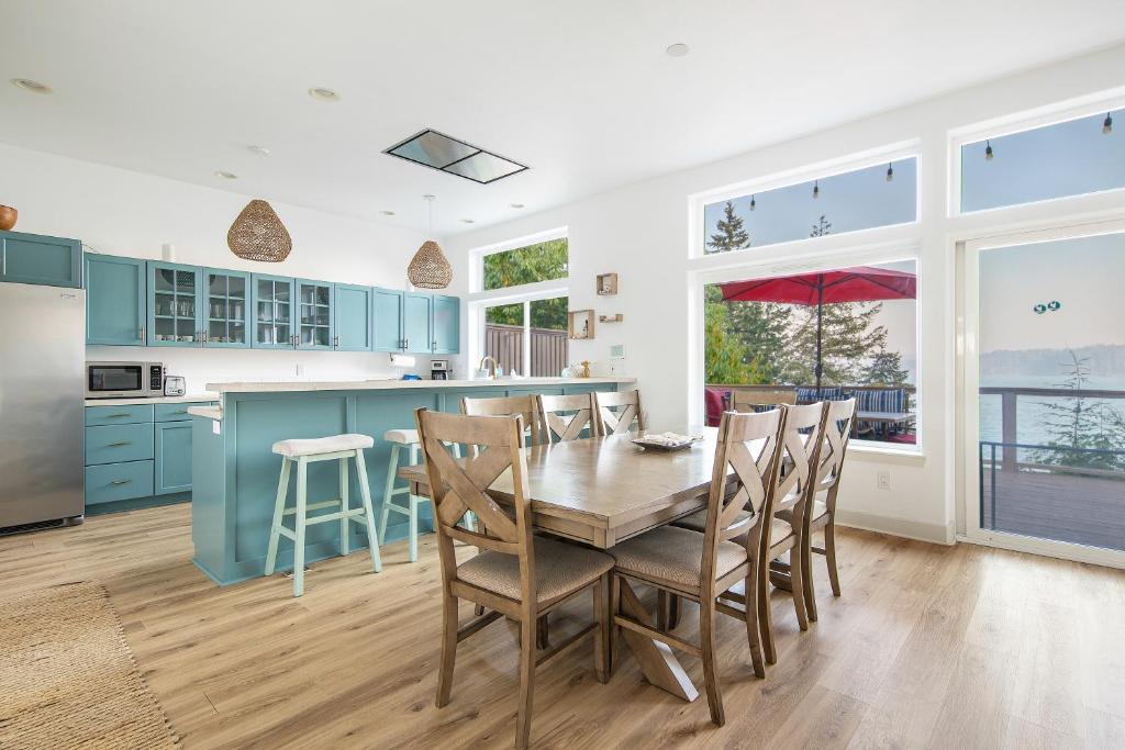 a kitchen with blue cabinets and a wooden table and chairs at Modern retreat w/ stunning views & hot tub in Hoodsport
