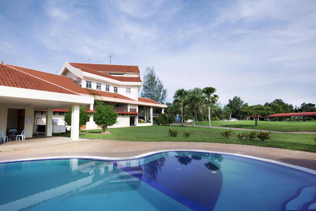 a swimming pool in front of a house at Kuala Terengganu Golf Resort by Ancasa Hotels & Resorts in Kuala Terengganu