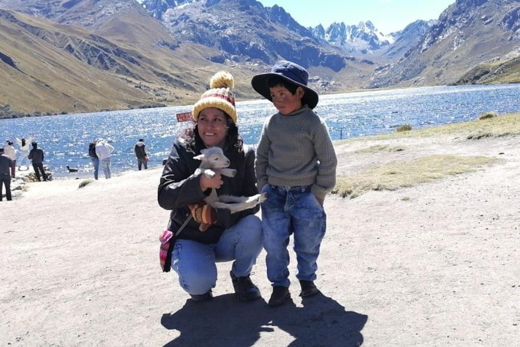 Eine Frau und ein Kind stehen neben einem See in der Unterkunft Posada Shumac Ñahui baño privado y ducha caliente in Huaraz