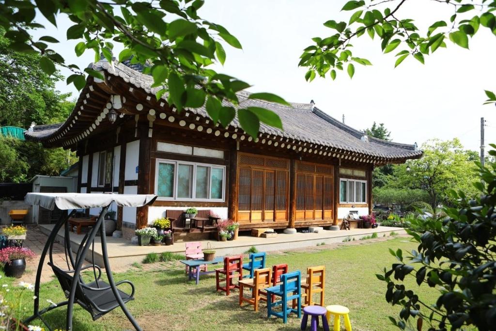 a house with colorful chairs in front of it at Damyang Flower & Hanok in Damyang