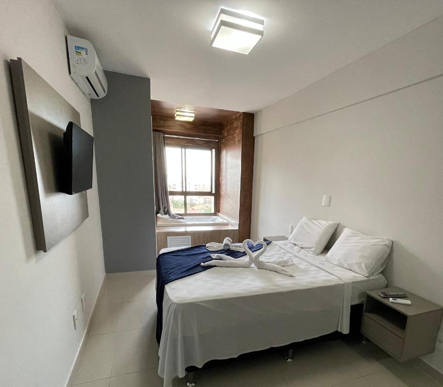 um pequeno quarto com uma cama e uma janela em DUPLEX com Hidromassagem total de 02 QUARTOS e Vista MAR em Aracaju