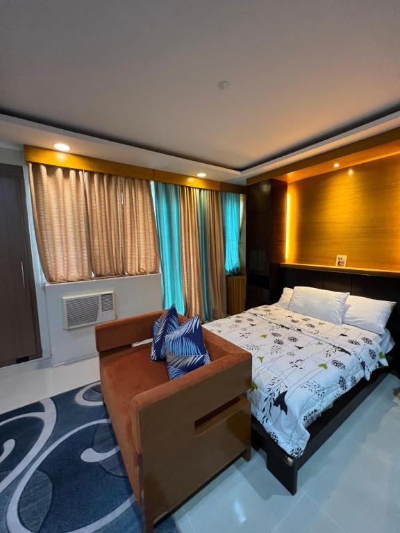 a bedroom with a bed and a large window at One Palmtree Villas Airport Condo in Manila