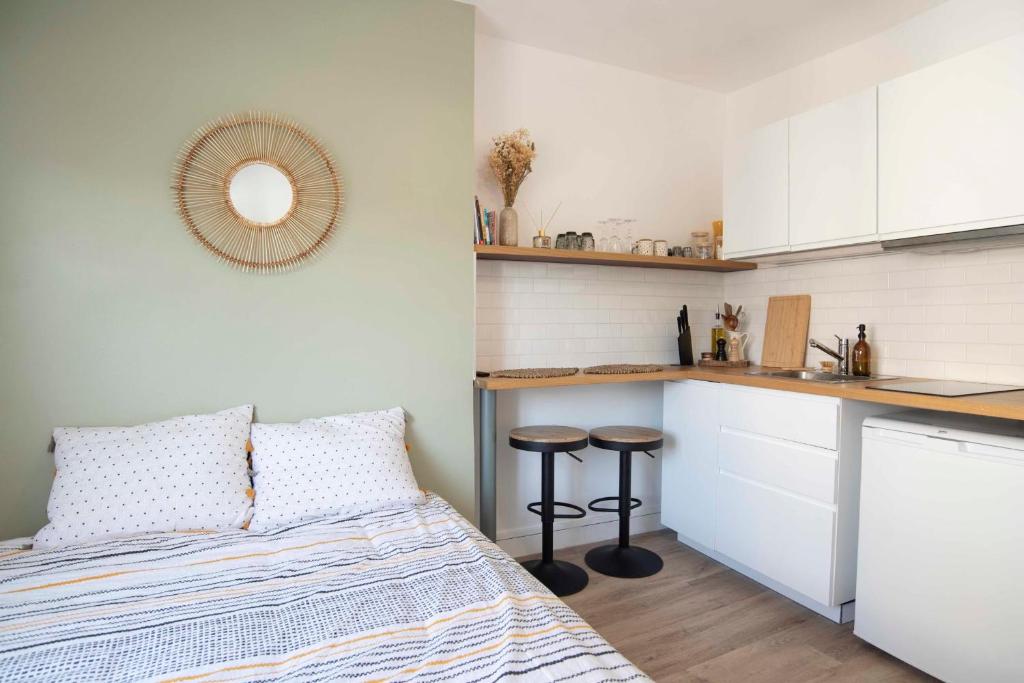 une petite chambre avec un lit et une cuisine dans l'établissement Charmant studio de 14m au coeur de Lyon, à Lyon