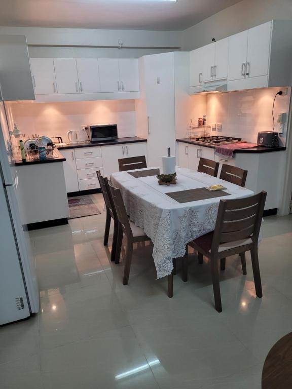 a kitchen with a table and chairs and a kitchen with white cabinets at Meadroad homestay &Tours in Suva