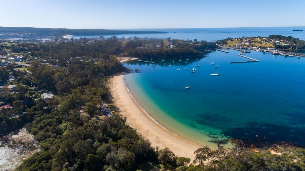 Una vista aérea de una playa con barcos en el agua. en Eden Motel, en Eden